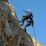 Two descending a steep drop using a rope